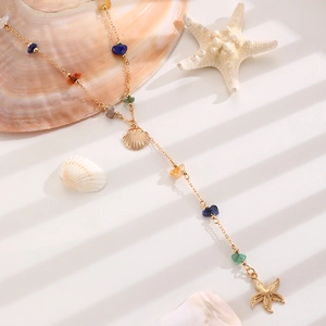 Detail einer Boho-Goldkette mit bunten Natursteinen, Muschel- und Seesternanhänger