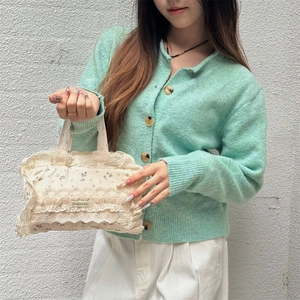 Vue détaillée du sac cabas en toile fleurie avec dentelle tenu par un mannequin élégant