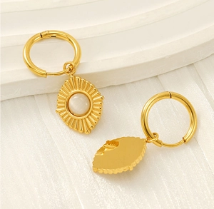 Detailed view of 18K gold-plated stainless steel sunburst earrings with cat eye stones