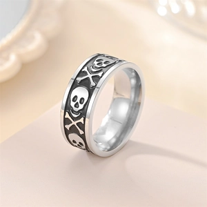 Macro detail of silver and black skull engraved band ring with punk relief texture