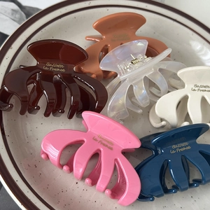 Set of 6 French style matte hair claws in assorted colors on a ceramic tray