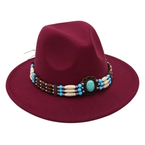 Close-up of bohemian style turquoise beads and ethnic woven band on burgundy wool fedora hat