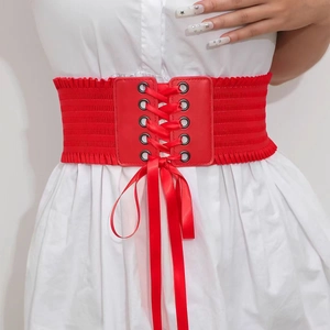 Close-up of red lace-up corset belt with elastic band and leather front on white dress