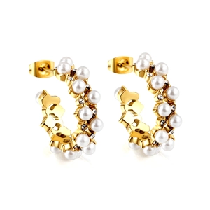 Golden C-shaped hoop earrings with pearls and rhinestones on a white background