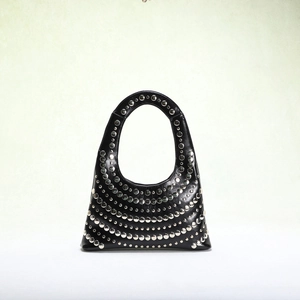 Close-up of silver studs on black leather bag showcasing punk style metal hardware