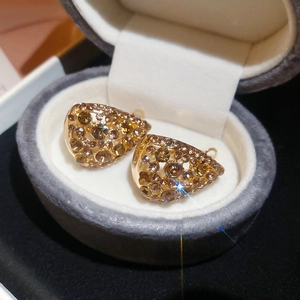Close-up of gold drop earrings with champagne crystals in a velvet jewelry box