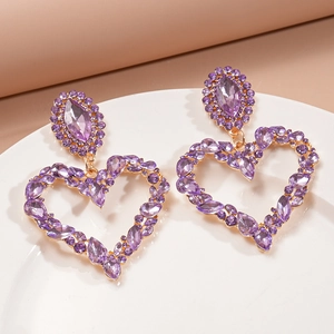 Detail of oversized purple rhinestone heart drop earrings with intricate crystal inlay