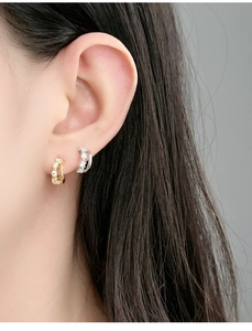 Close-up of double-layer rhinestone earrings in gold and silver finish on ear