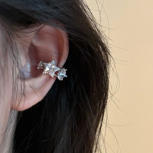 Silver star ear cuff featuring zircon stones worn on the ear cartilage in a casual style
