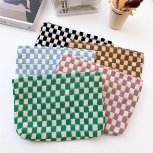 Flat lay of colorful checkered knit cosmetic bags in green, blue, and purple tones