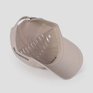 Detail of adjustable metal buckle and YOUR DREAMS embroidery on beige cotton cap