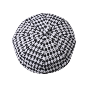 Top view detail of the houndstooth pattern and thick wool texture on a beret hat