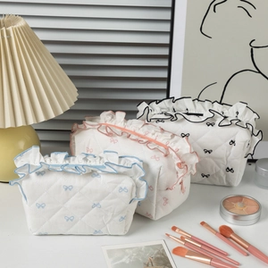 Quilted cosmetic bags with lace trim and bow embroidery in three soft pastel colors