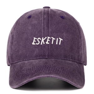 Close-up of white ESKETIT embroidery on a washed purple vintage cotton baseball cap