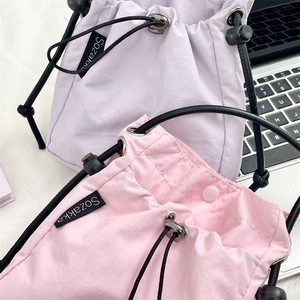 Dettaglio di pochette con coulisse rosa e viola in nylon ripstop testurizzato e logo