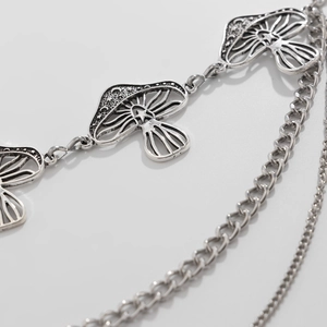 Close-up of vintage silver layered waist chain featuring hollow mushroom pendants and moon patterns