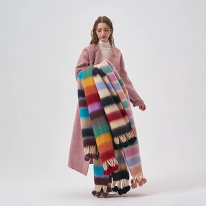 Colorful striped knit scarf with decorative pom-poms for winter warmth and style