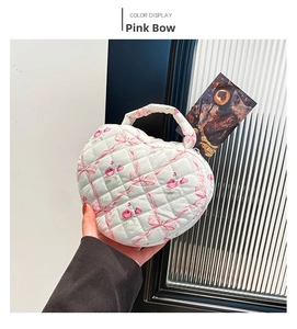 Detail of heart-shaped quilted makeup bag featuring pink rose and bow floral patterns