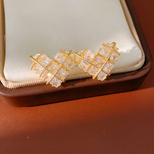 Gros plan de boucles d'oreilles cœur plaquées or 18 carats avec zircons dans un coffret