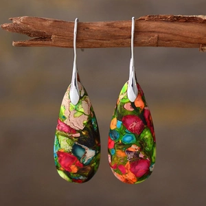 Macro shot of bohemian water drop earrings with colorful mosaic stones on a branch