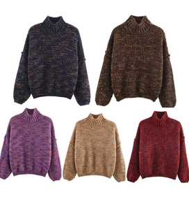 Close-up of thick high-neck sweaters in five mixed colors with chunky knit texture