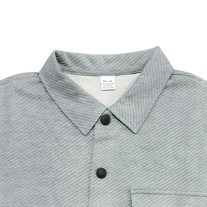 Close-up of gray twill jacket collar with size M label and fabric texture detail