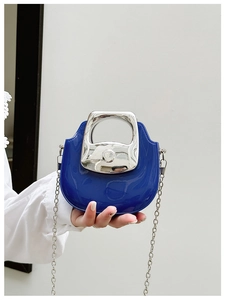 Close-up of blue patent leather mini bag with silver metal handle and chain strap