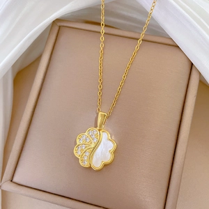Detail of clover cloud necklace with gold finish, sparkling crystals and white mother of pearl