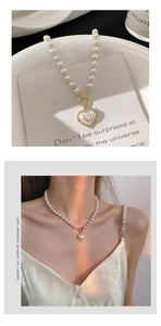 Detail of heart pendant pearl necklace with shimmering inlay and golden OT toggle clasp
