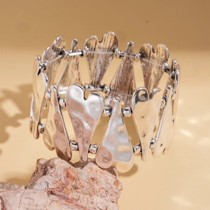 Détail du bracelet élastique cœur argenté avec texture métallique martelée vintage
