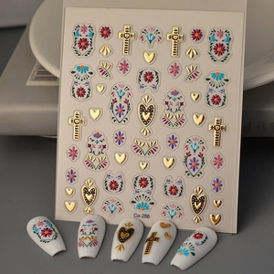 Macro view of bohemian nail stickers with gold crosses and vintage flower patterns