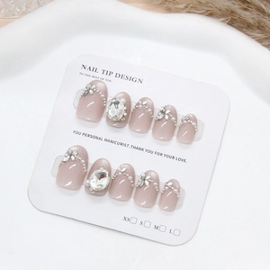Handmade nude pink press-on nails with sparkling rhinestones and pearl flower designs