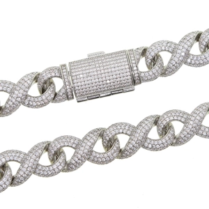 Macro shot of silver Cuban link chain with iced-out pave cubic zirconia on a white background