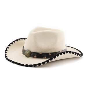 Detail of cream cowboy hat with star-studded band and rustic metal badge on felt