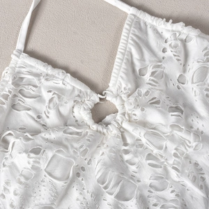Détail de la robe blanche ajourée montrant le col licou à anneau et la texture tricot