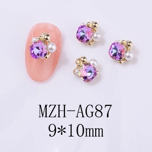 Detailansicht lila quadratischer Kristall Nagelschmuck mit Perlen und Goldperlen