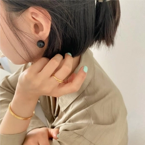 Minimalist gold bamboo ring, slim bangle and black onyx studs worn by a female model