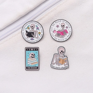 Set of 4 skeleton reading enamel pins for book lovers on a white canvas background