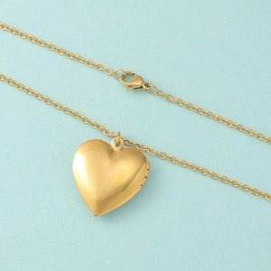 Close-up of golden stainless steel heart photo locket necklace with a small side hinge