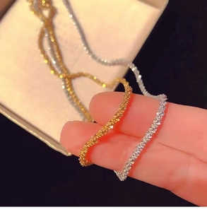 Detailed macro view of gold and silver sparkling popcorn chain necklaces with beaded texture