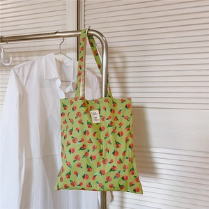 Detailaufnahme der hellgrünen Stofftasche mit Blumenmuster und weißem Kunstetikett