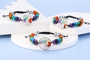 Detailed view of handmade chakra stone tree of life bracelet on a stone pedestal