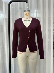 Detailansicht der burgunderroten Strickjacke mit asymmetrischem Verschluss und Goldknöpfen
