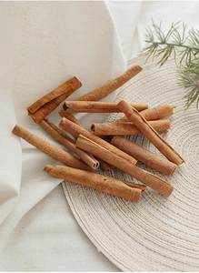 Natural dried cinnamon sticks arranged on a woven mat for Christmas rustic decor settings