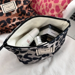 Tre colori di beauty case leopardati in tela con dettagli su interno e chiusura a zip