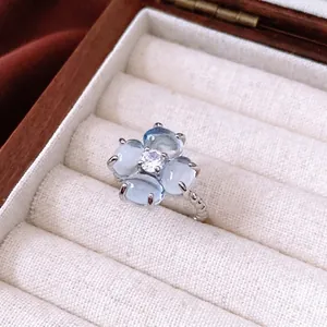 Elegant floral open ring with light blue zircon petals and a twisted silver rope band