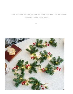 Detail of LED Christmas pine cone string lights with red berries on white plush rug