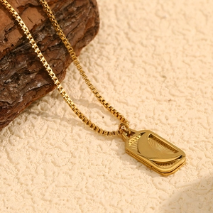 Dettaglio di collana placcata oro 18 carati con pendente luna e sole incisi su catena