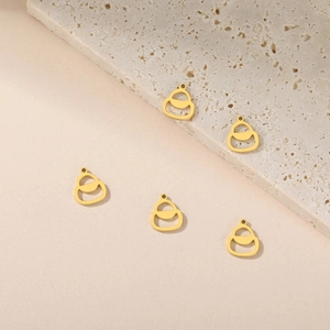 Set of five hollow gold charms in bag and gourd shapes on beige stone for jewelry making