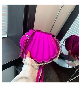 Detailansicht der fuchsiafarbenen Muscheltasche aus PU-Leder mit Perlengriff und Spiegelung